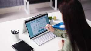 woman sitting on a desk taking a survey on a laptop