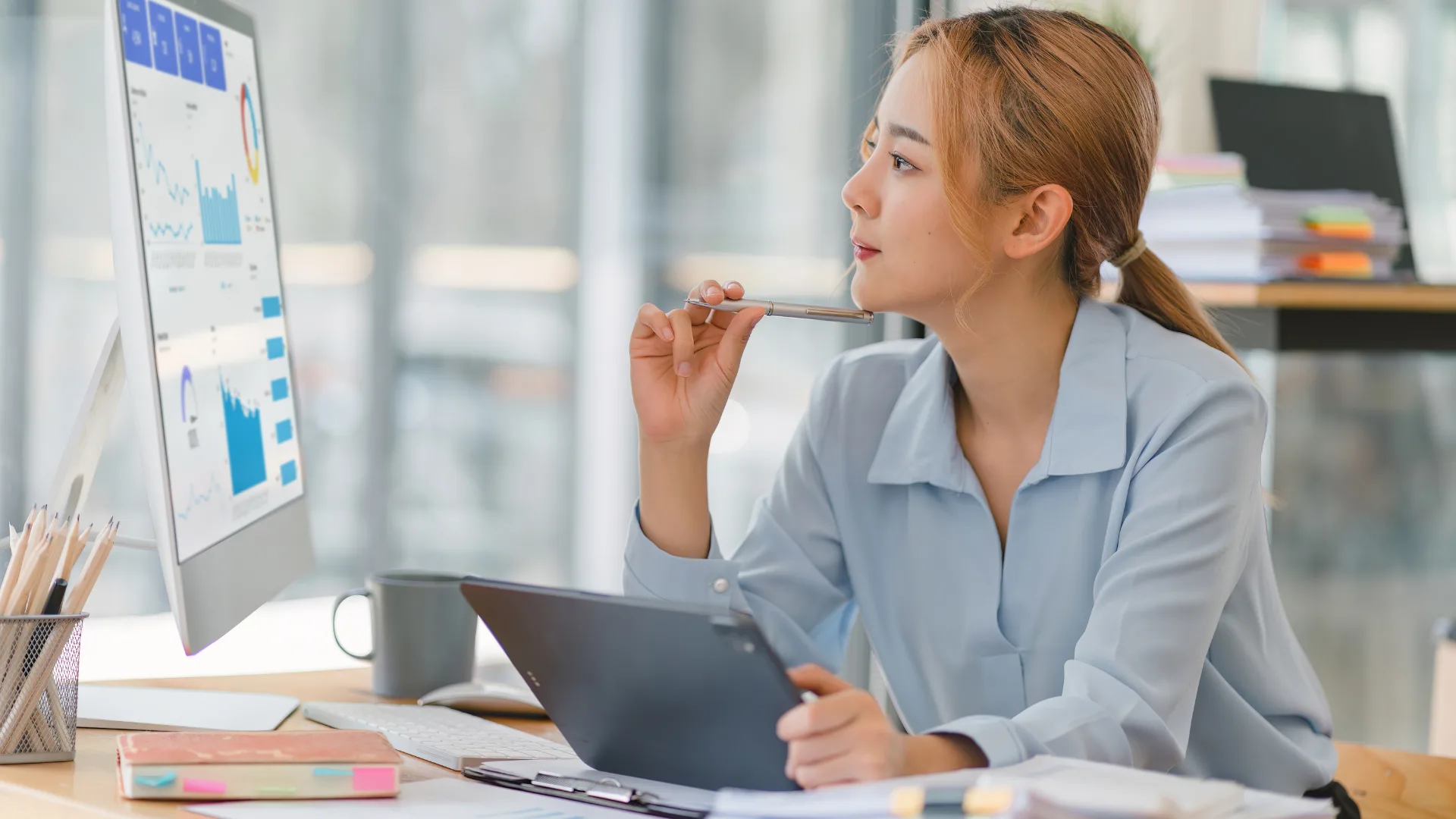 business woman looking at computer screen with analytics / kpi on the screen