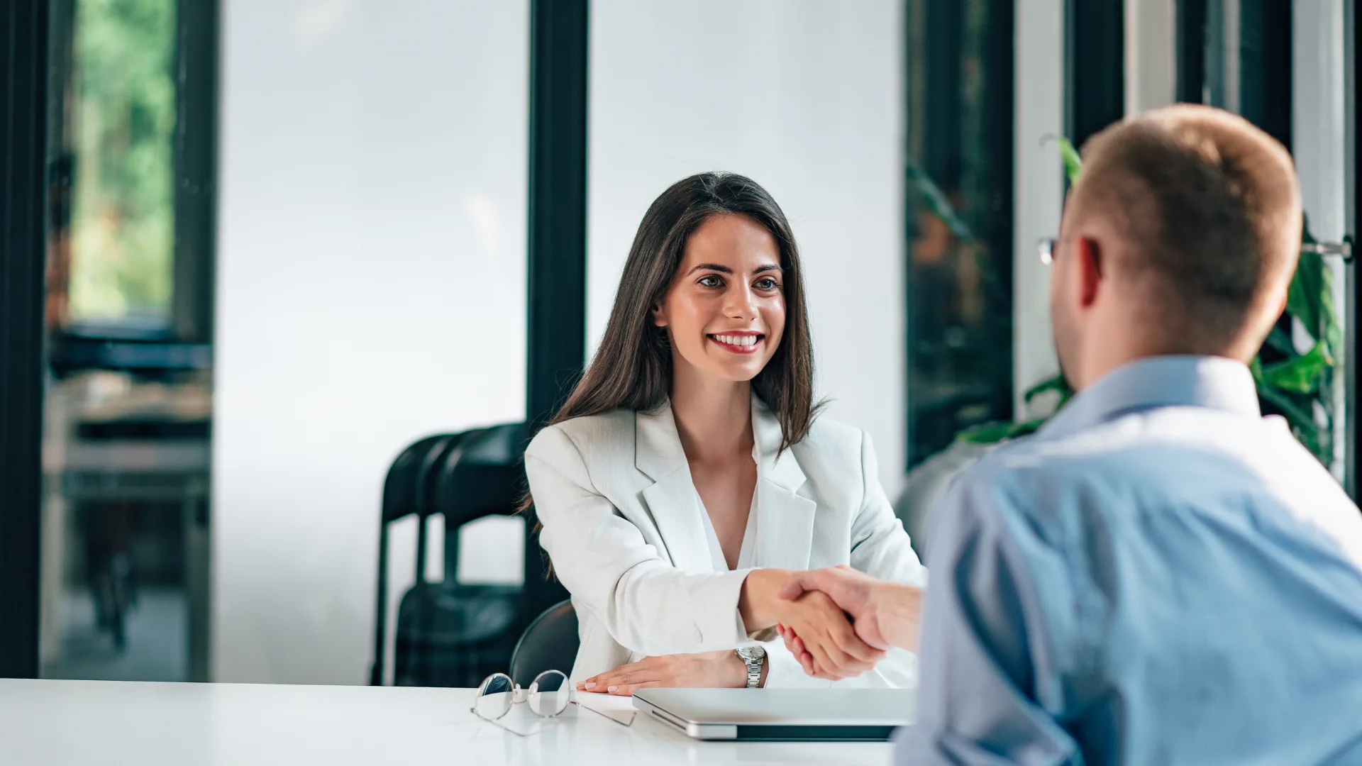 business man and woman giving a handshake to each other during an interview in a professional setting
